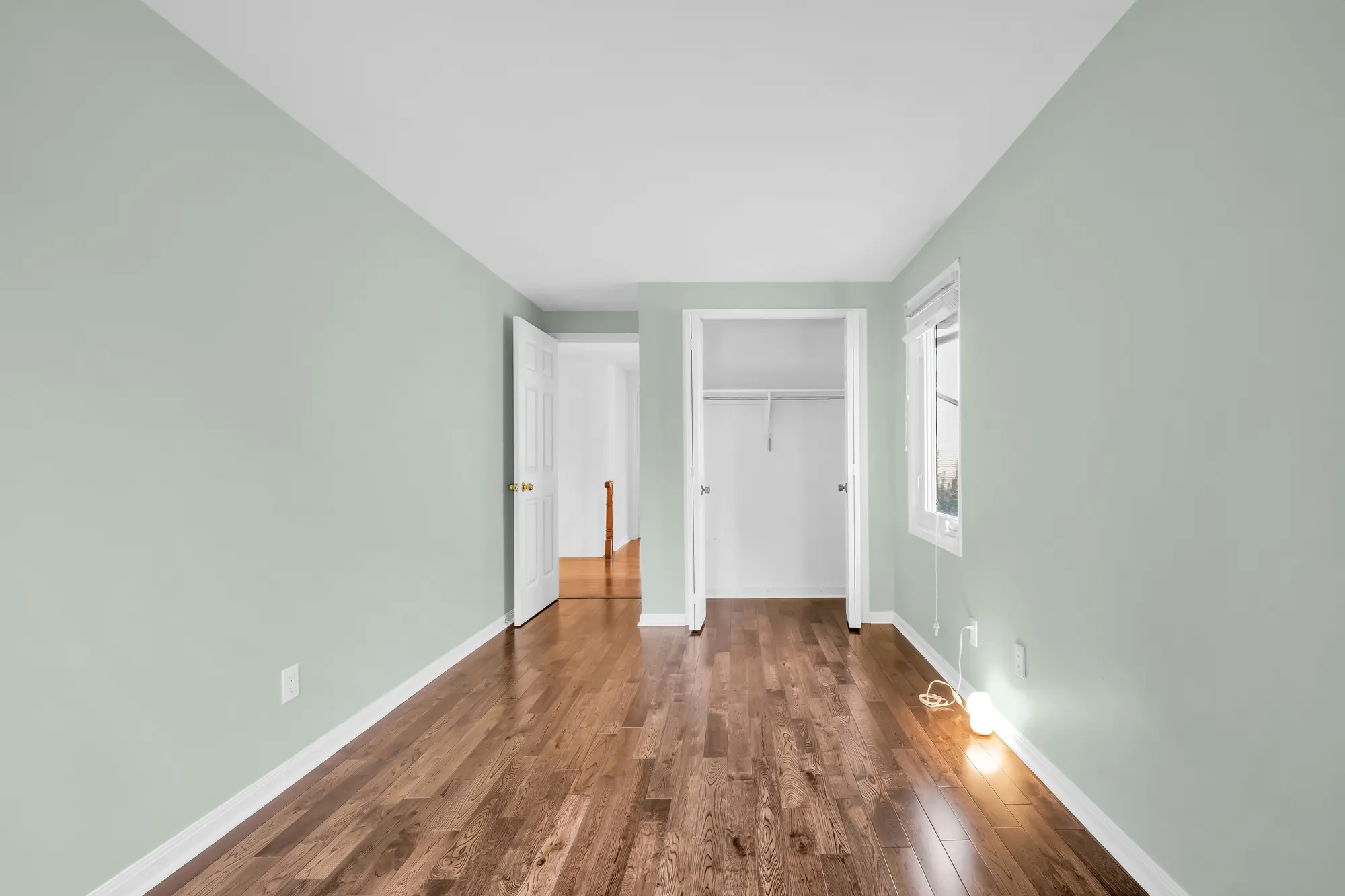 The second green bedroom toward its open closet and the door