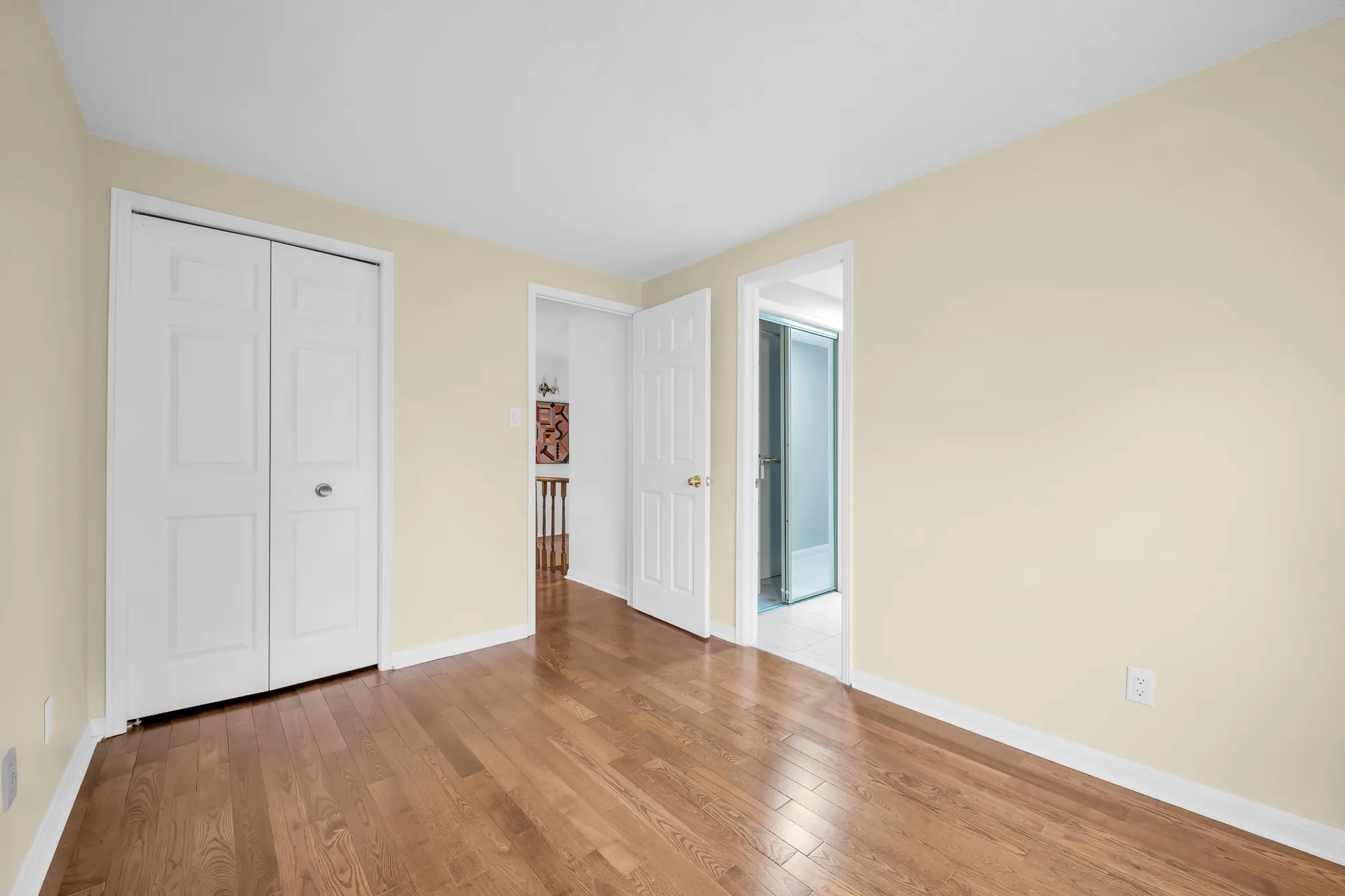 The same bedroom toward its double closet and the door to the hall