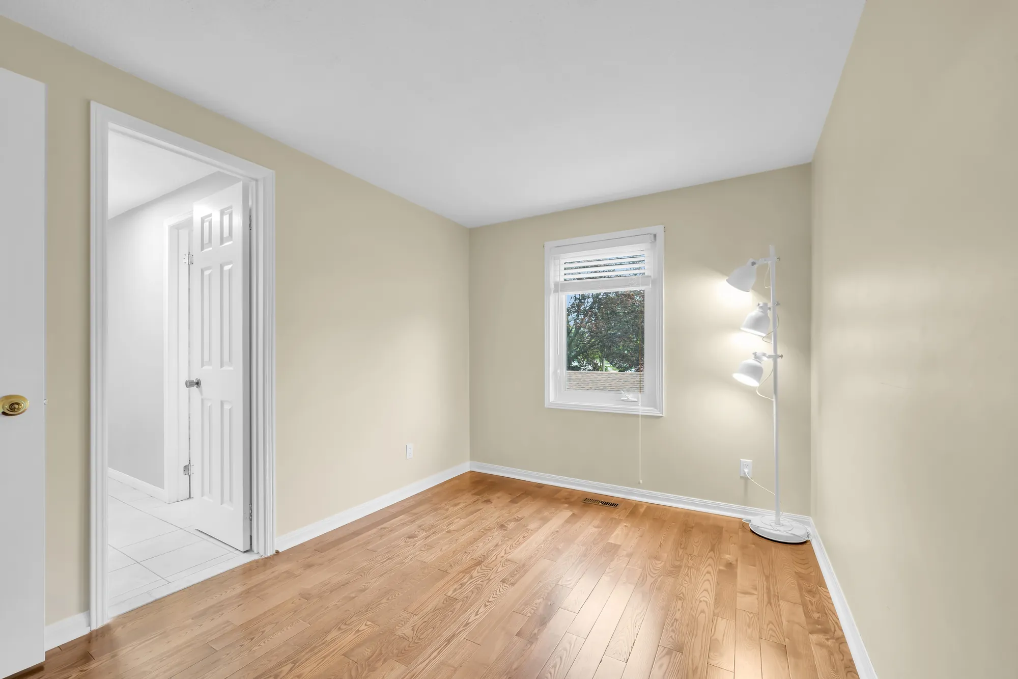 The yellow bedroom from the closet side, the window at the end, the doorway at the left