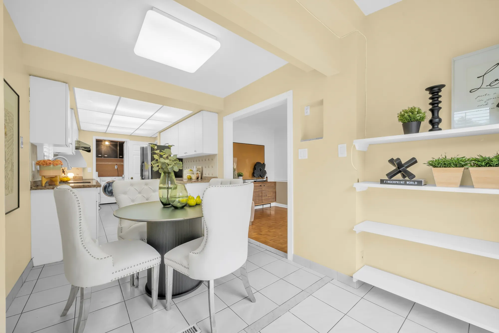The breakfast table, open shelves on the wall, the kitchen and the laundry beyond