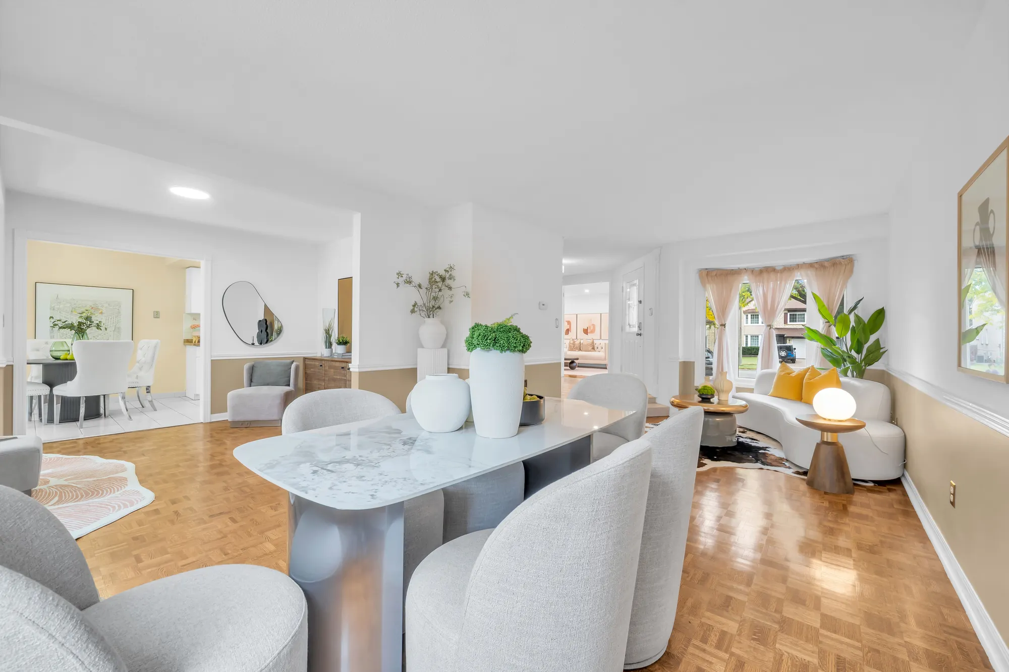 From the dining table across the room to the living room and the bay window at the front, the breakfast room through a doorway at the left